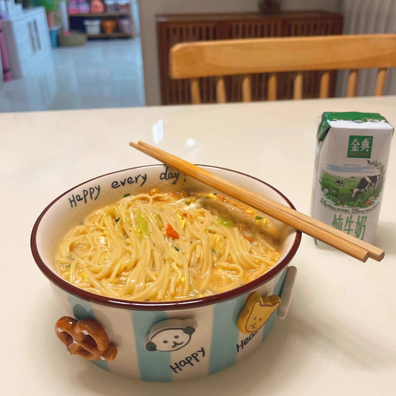 A kawaii ramen bowl with chopsticks and a carton of milk on a table