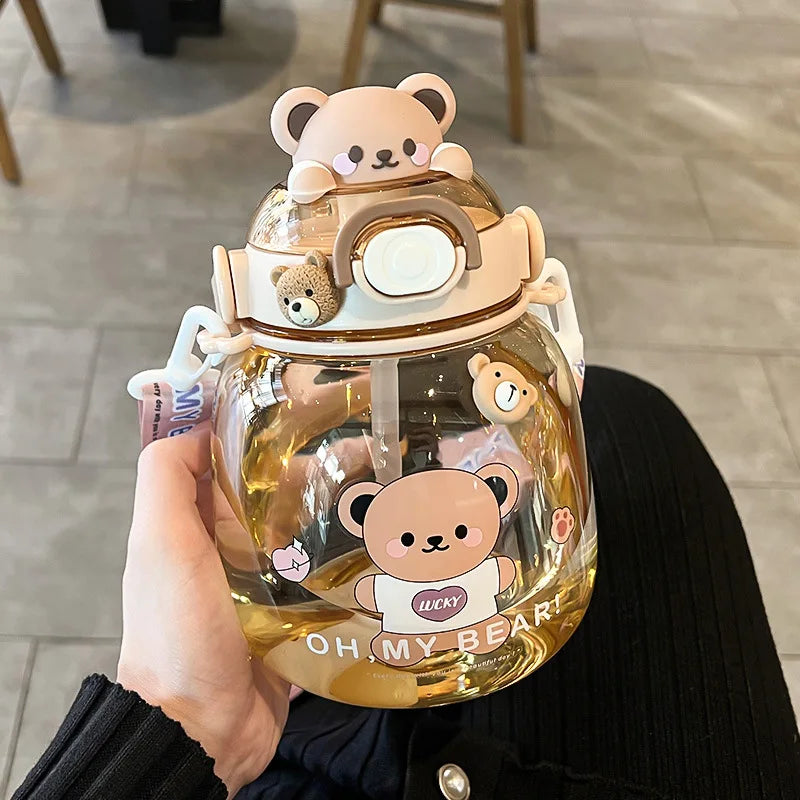 Clear kawaii water bottle with bear-themed design held by a person indoors.