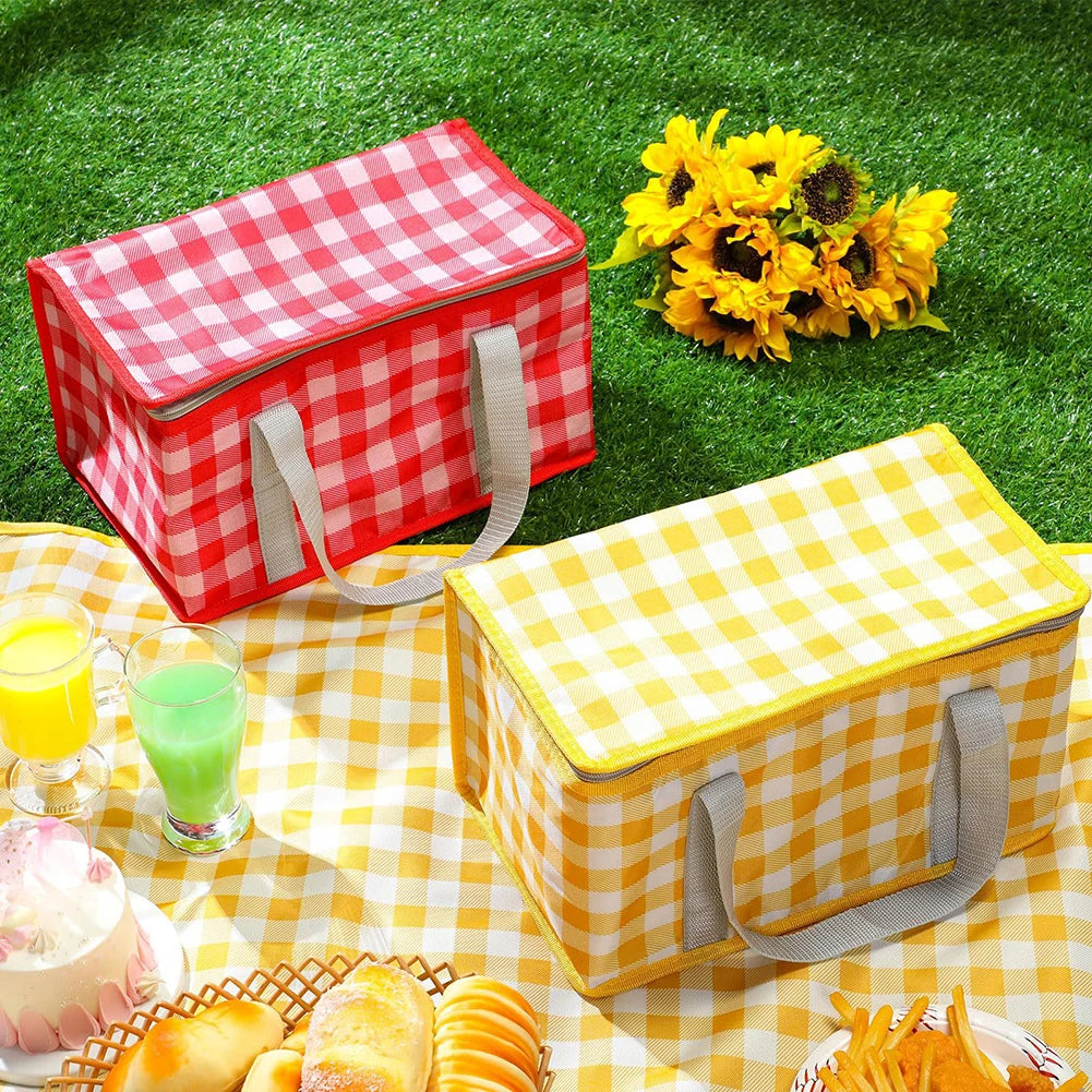 Two picnic kawaii lunch bags with a checkered pattern on a grassy background with food and drinks.