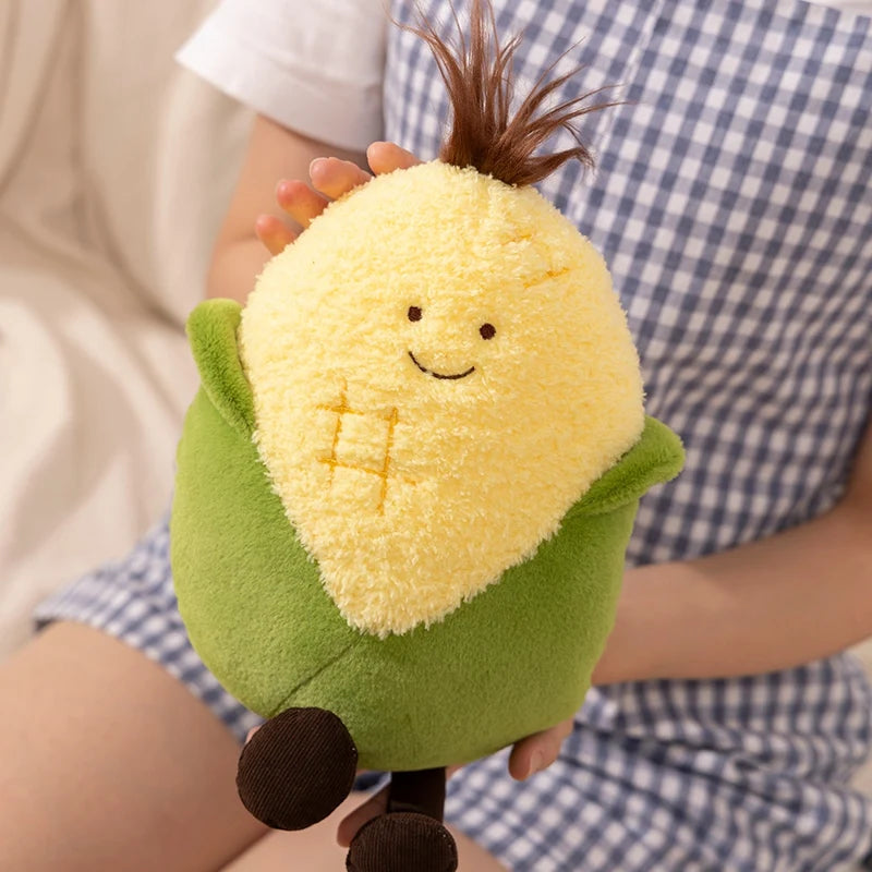 Plush toy resembling a corn on the cob held by a person wearing a checkered shirt.