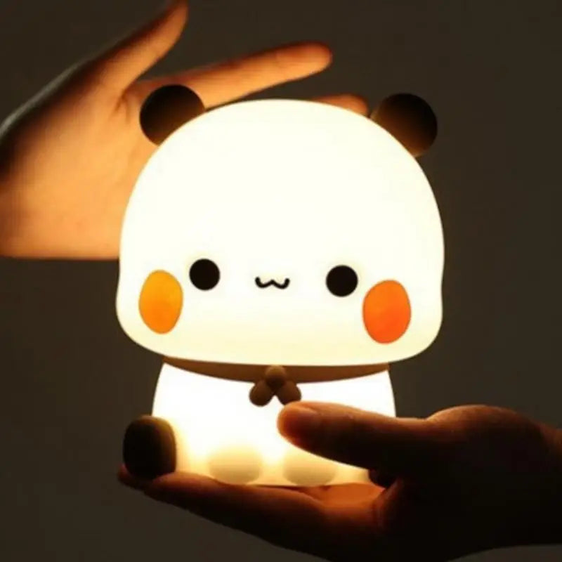 Cute cartoon-style kawaii night light held in hands against a dark background