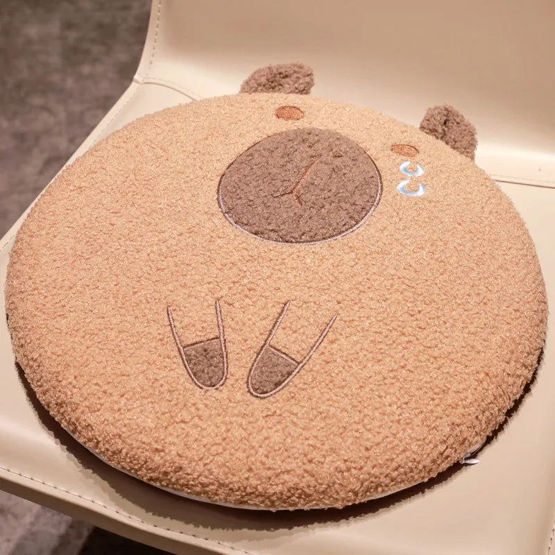 Round, beige kawaii cushion with cartoon face design on a white surface