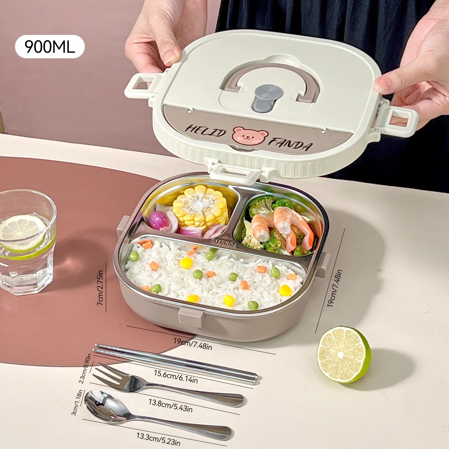 Kawaii bento box with compartments of food, utensils, and a glass of water on a table.