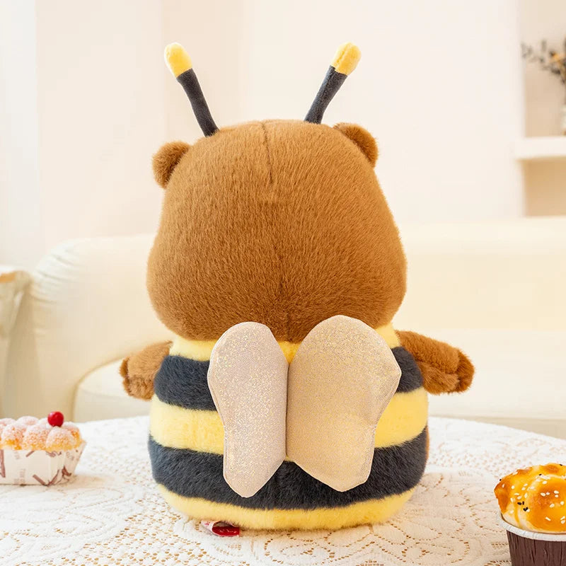 Kawaii plush toy shaped like a bear with bee wings and stripes on a light background