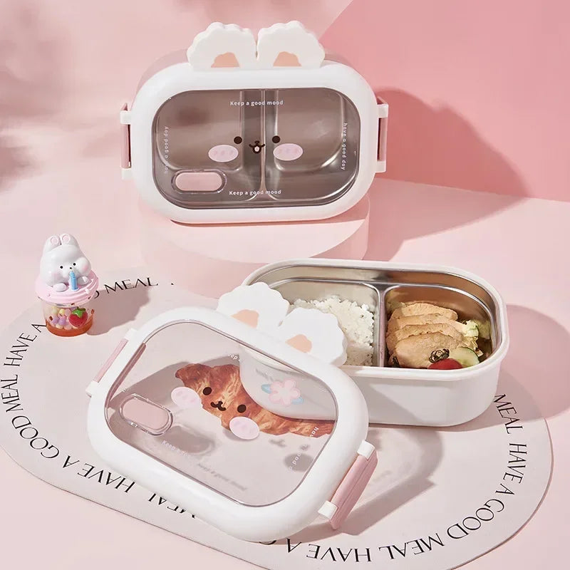 Two cute animal-themed kawaii lunch boxes on a pink surface with a small figurine.
