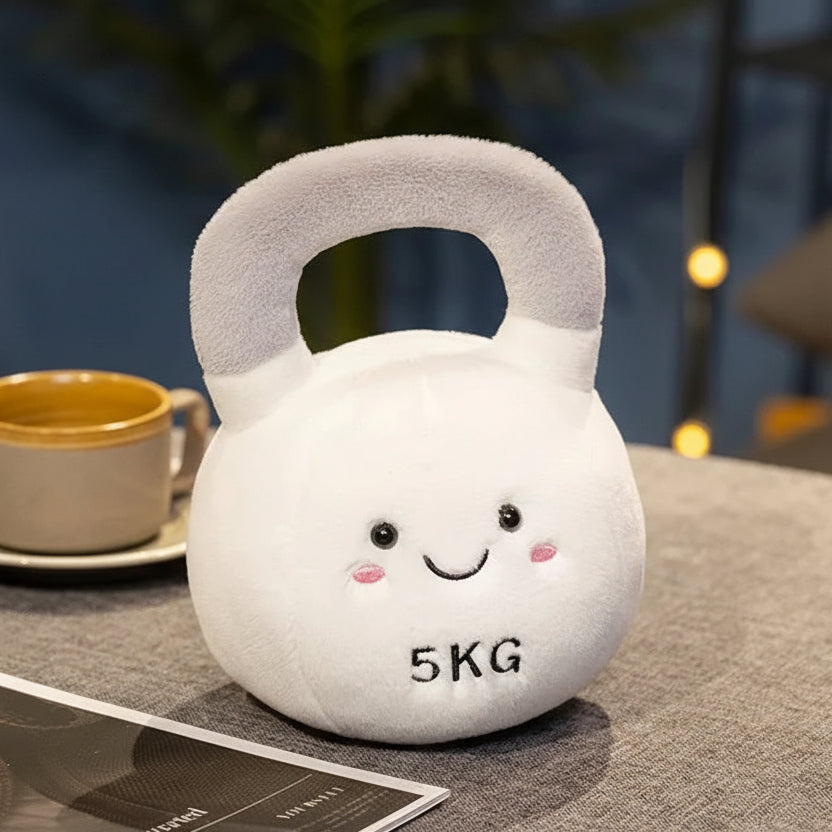 Kawaii plush toy kettlebell with face design on a table next to a cup and paper.