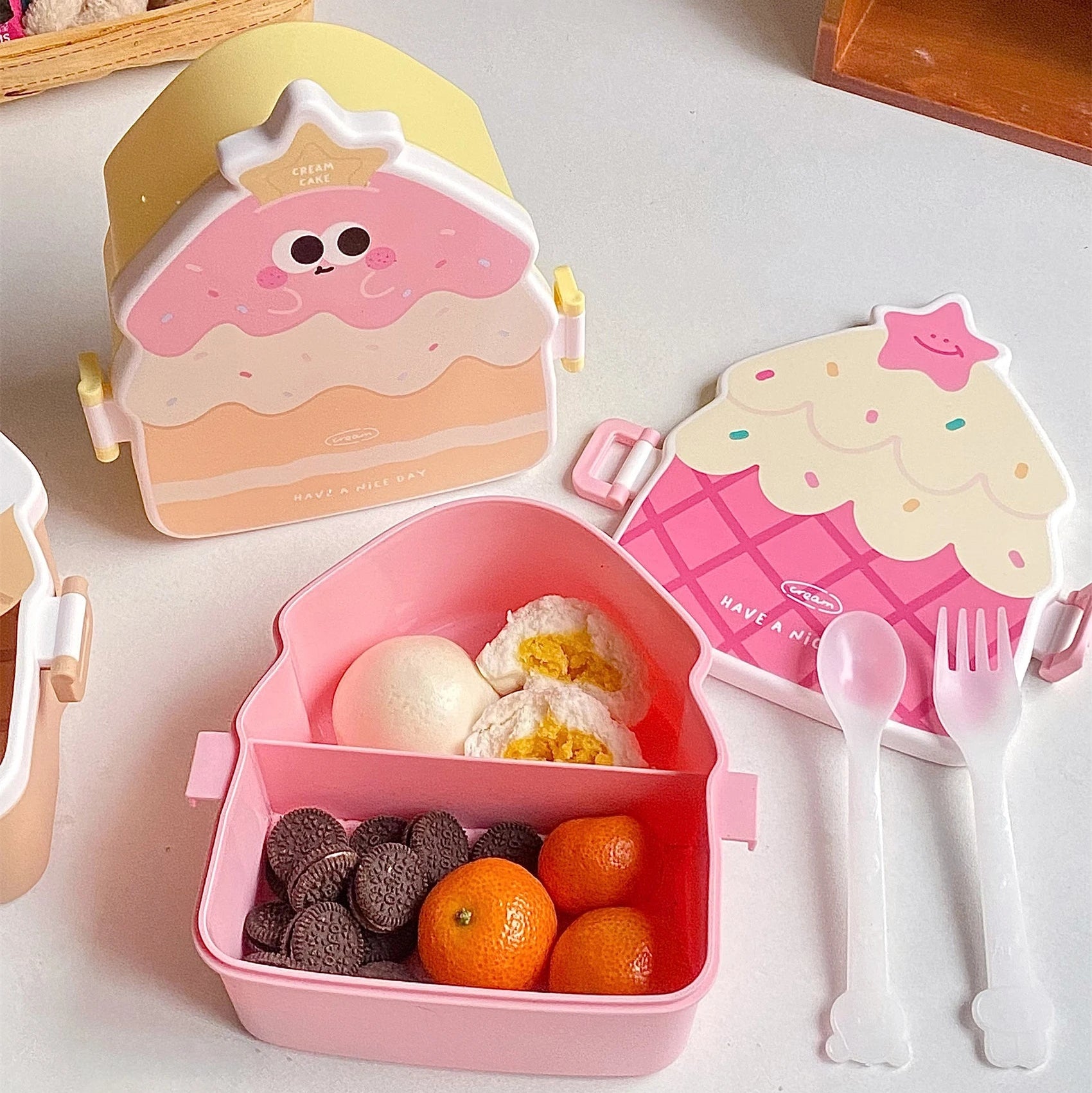 Kawaii-themed kawaii bento box with food and utensils on a light surface