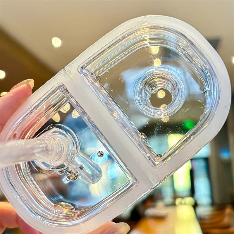 Kawaii water bottle with a straw held by a hand in an indoor setting