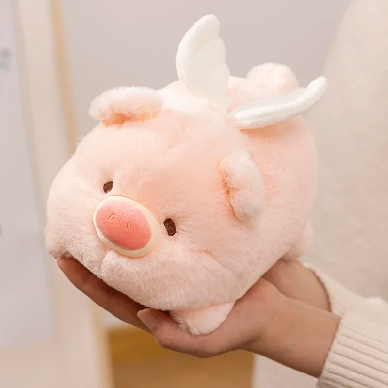 Kawaii plush toy resembling a pink creature with white horns held in hands against a neutral background