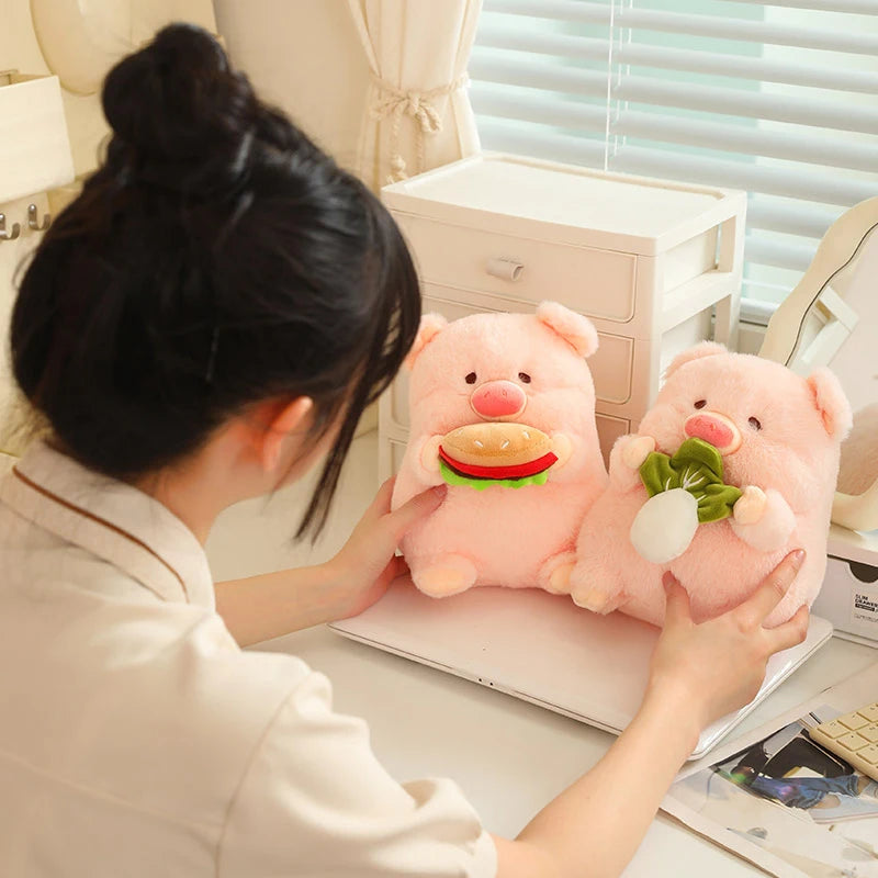 Person holding two kawaii plush pig toys with food items in an office setting
