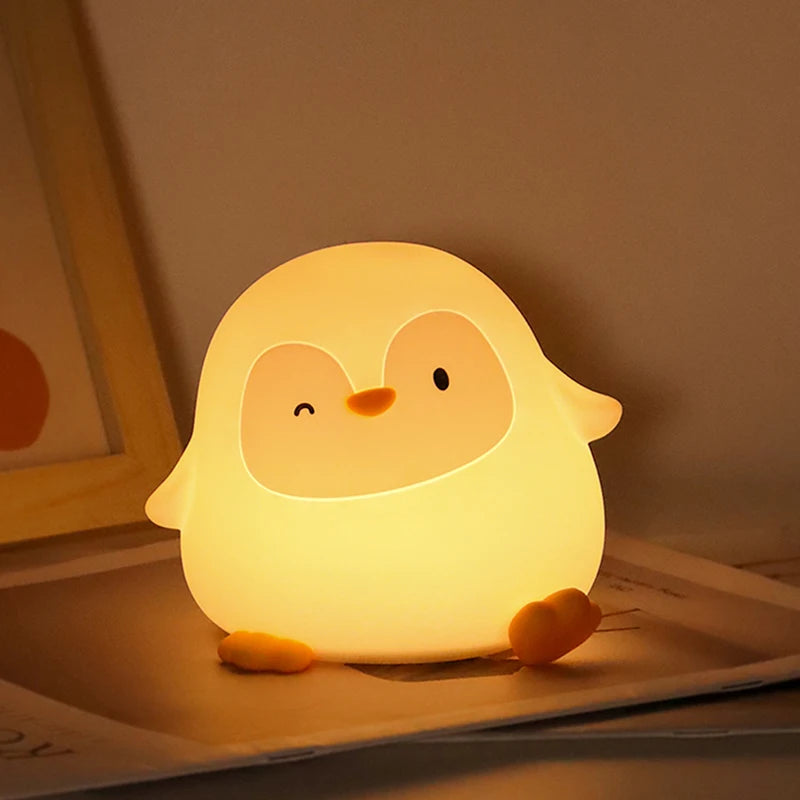 Cute kawaii chick-shaped night light emitting a warm glow on a surface.