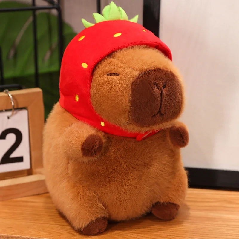 Kawaii plush toy resembling a bear wearing a red strawberry hat on a wooden surface.
