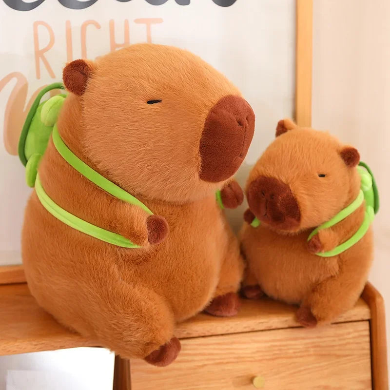 Two brown kawaii plush bears with green ribbons on a wooden surface.