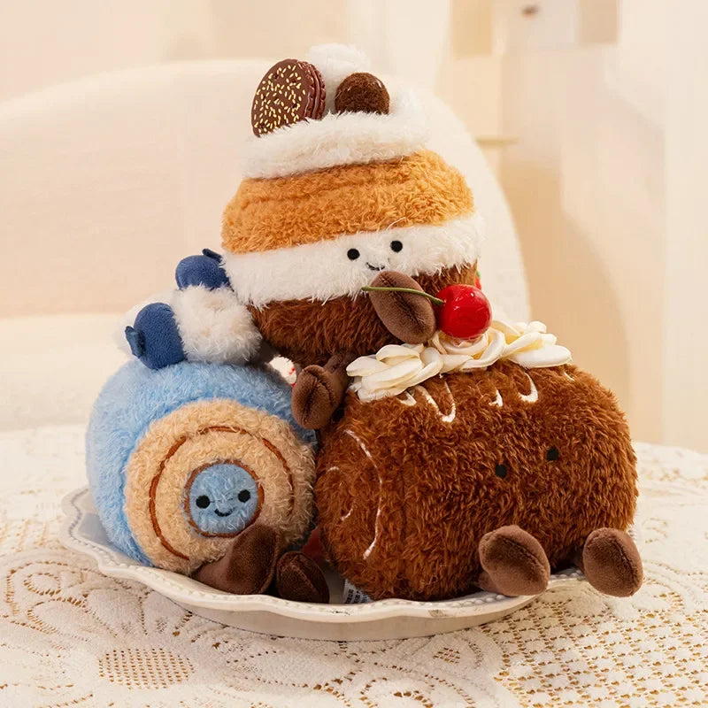 Two kawaii plush toys, one resembling a cake and the other a snail, on a white plate with a lace tablecloth.