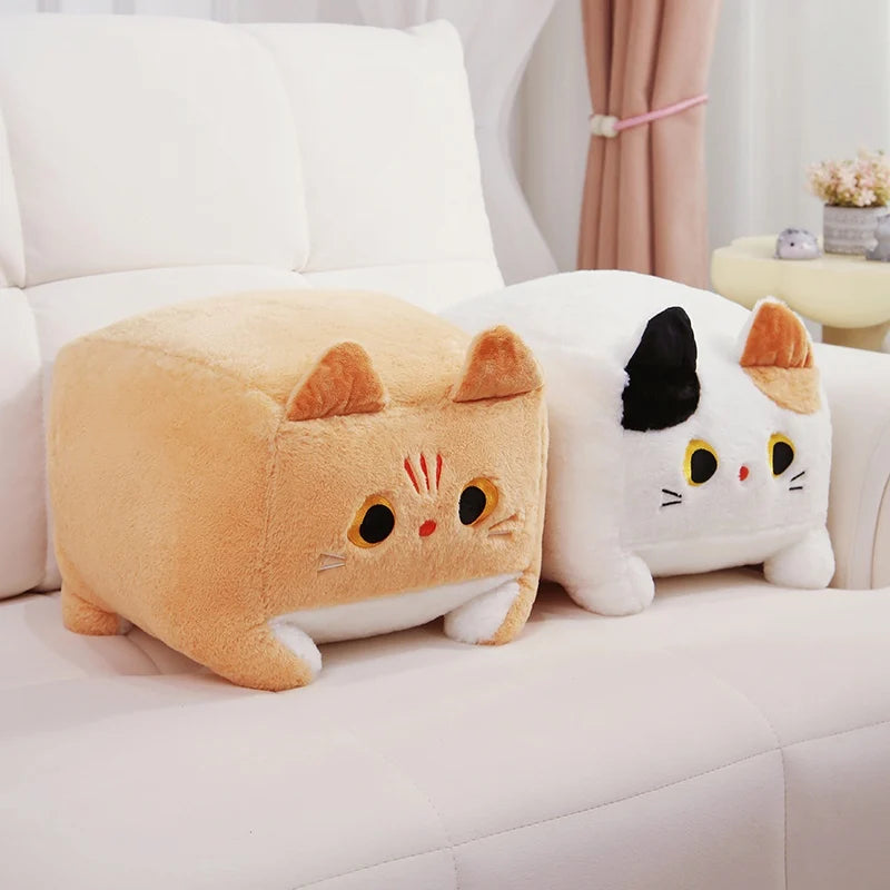 Two cat-shaped kawaii cushions on a white sofa with a neutral background