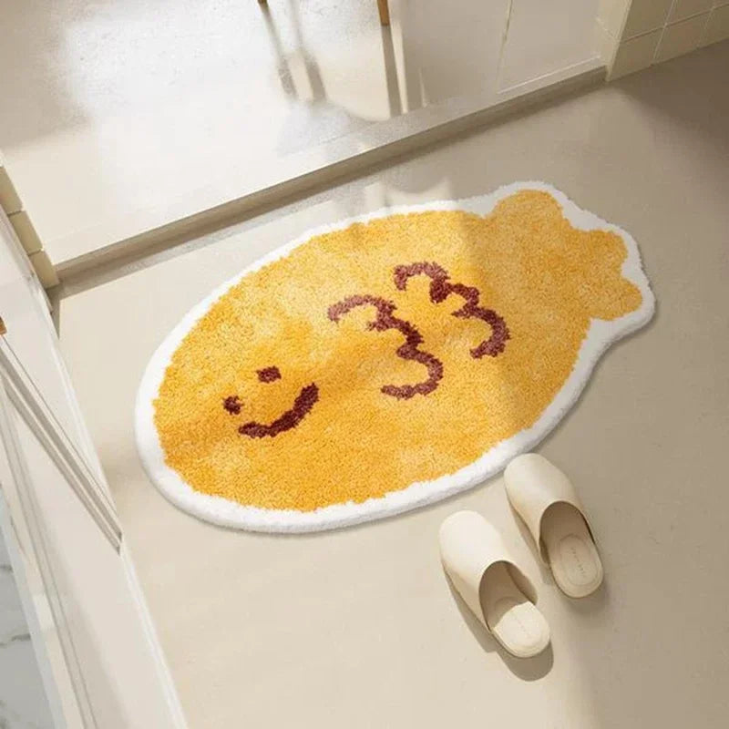 Yellow bath mat with Kawaii smiley face design on a bathroom floor.