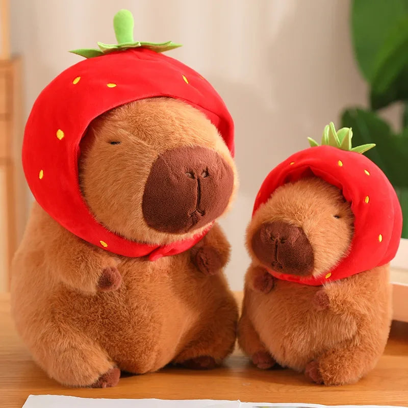 Two kawaii plush toys resembling bears wearing strawberry hats on a wooden surface.