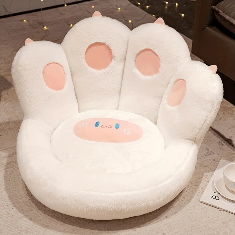White paw-shaped kawaii cushion with pink pads on a wooden floor.