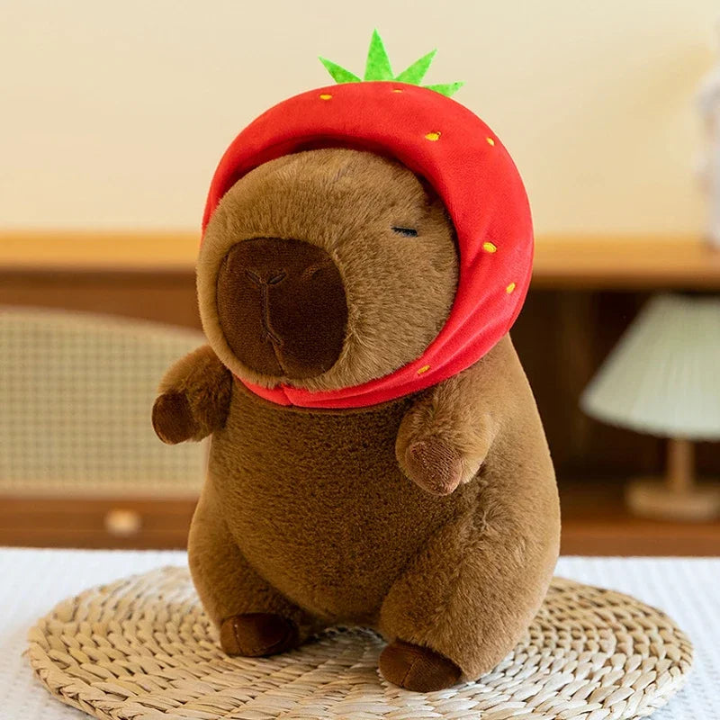Kawaii plush toy resembling a bear wearing a red strawberry hat on a woven mat.