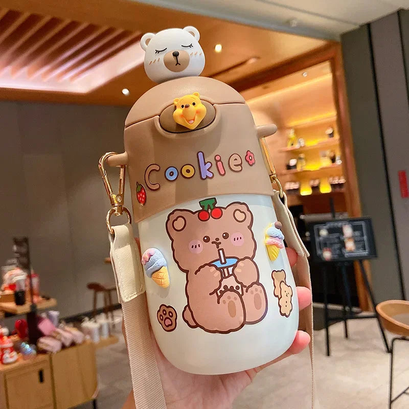 Cute bear-themed kawaii water bottle with a beige lid held in a hand, indoor setting.