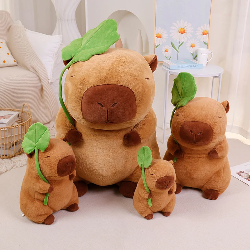 Set of brown kawaii plush toys with green leaves on a light surface