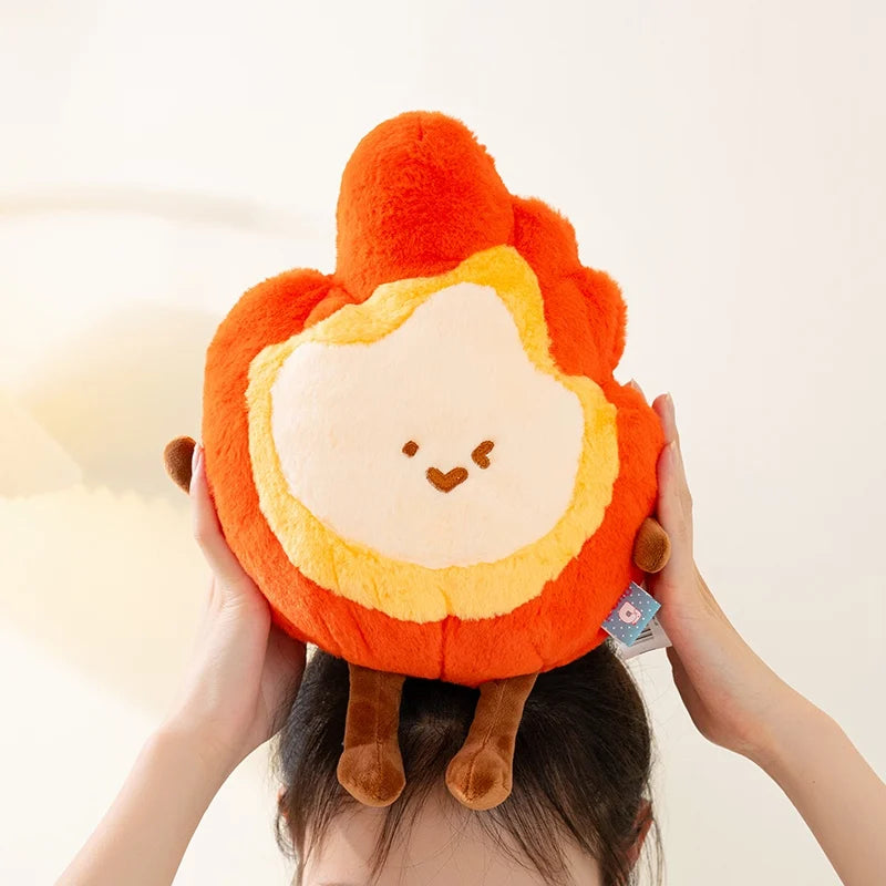 Kawaii plush toy shaped like a flame held by a person against a white background