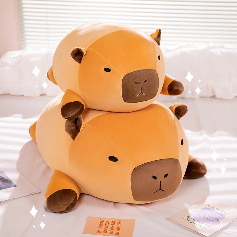 Two yellow kawaii plush toys resembling bears stacked on a white surface with a blurred background