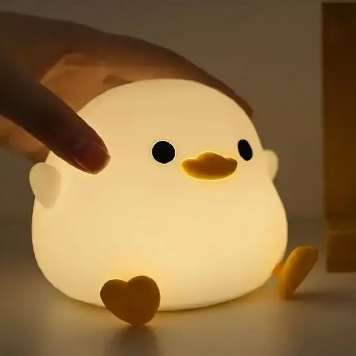 Cute chick-shaped night light being held by a hand with a blurred background