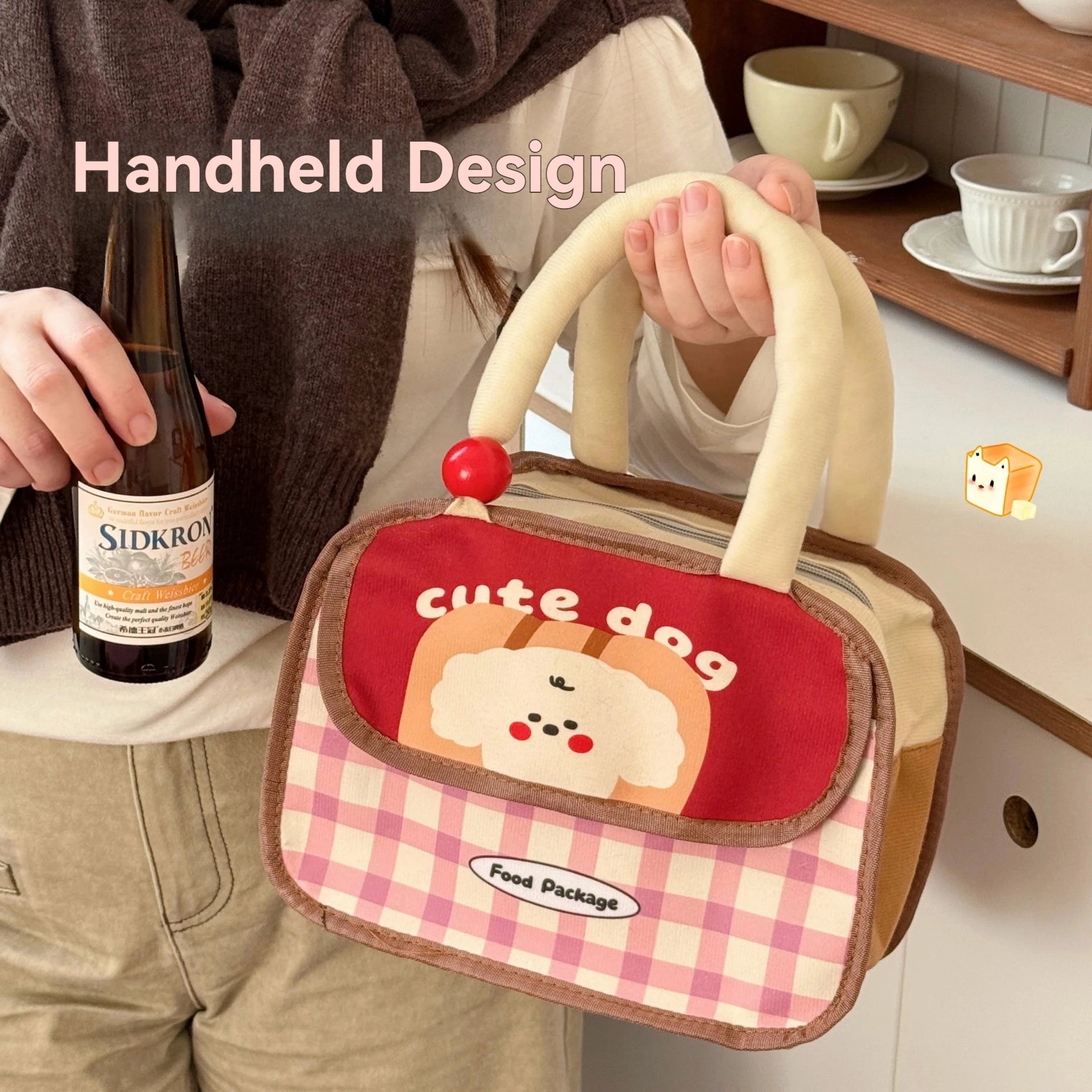 Kawaii lunch bag with 'cute dog' design held by a person, with a bottle of Sidkron in the background.