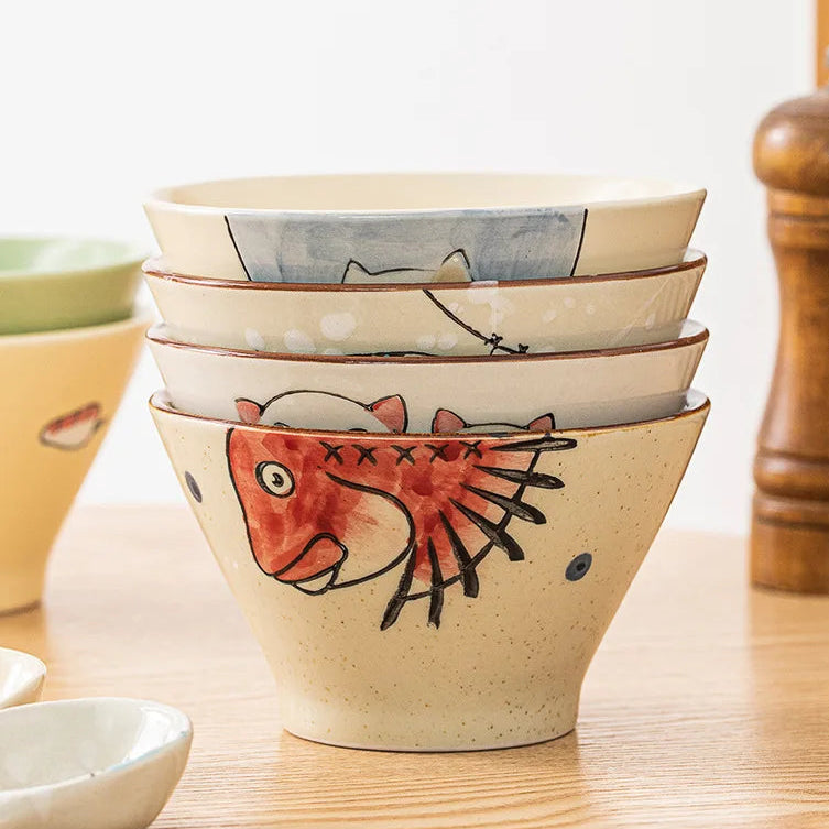 Set of ceramic kawaii ramen bowl with fish designs on a wooden surface