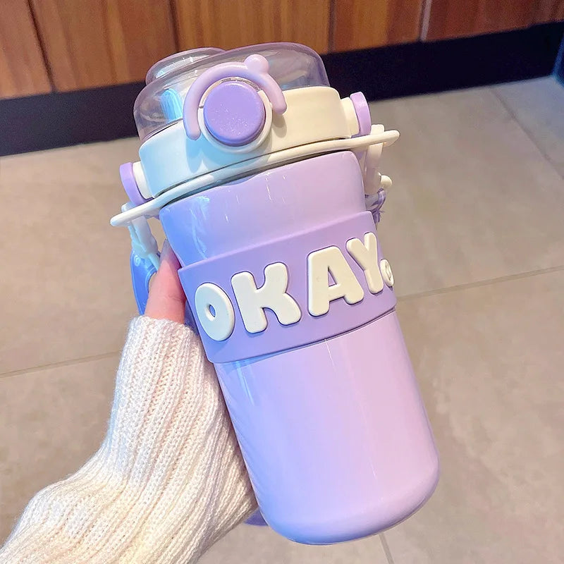 Colorful kawaii water bottle with 'OKAY' text held by a person.