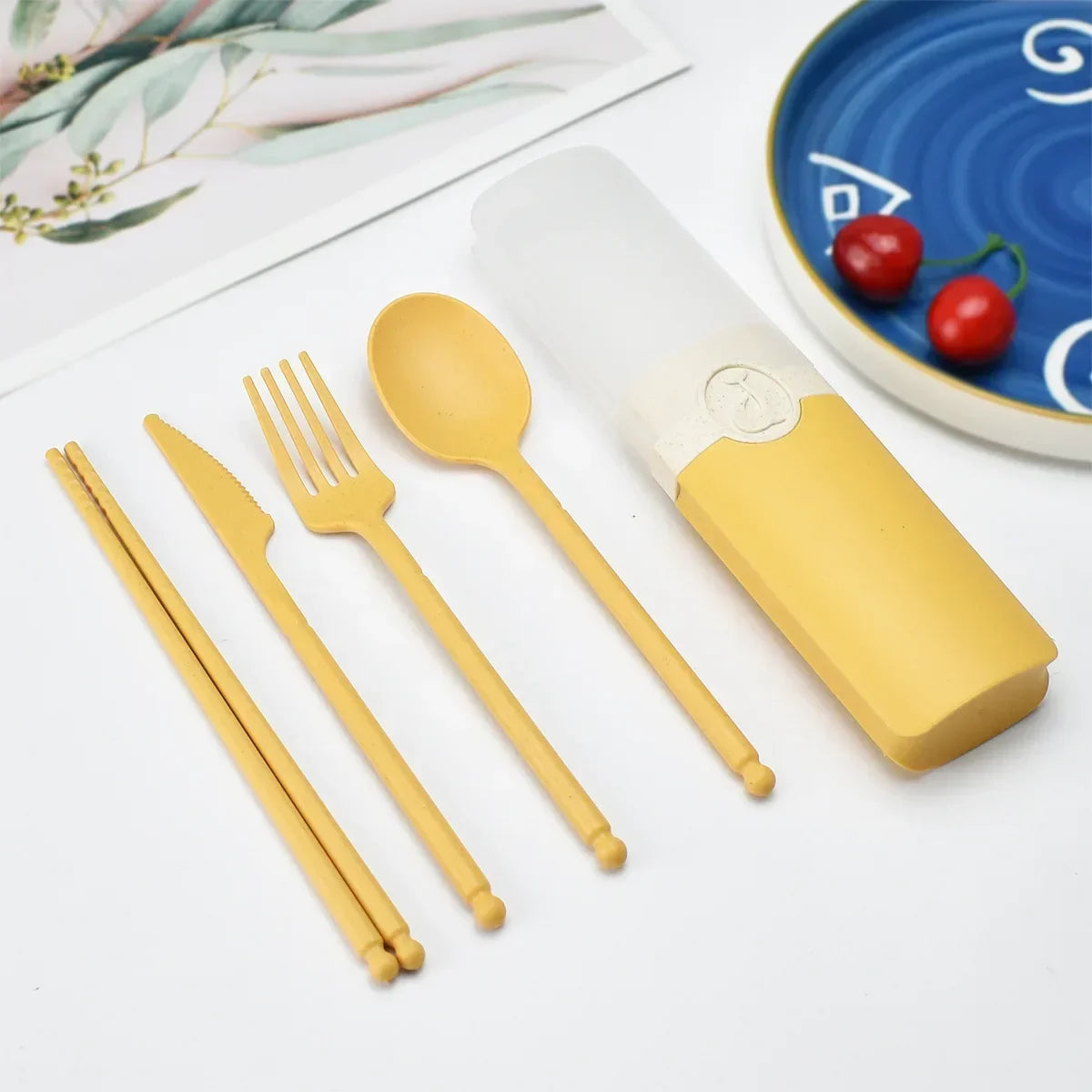 A set of yellow kawaii utensils with case on a table