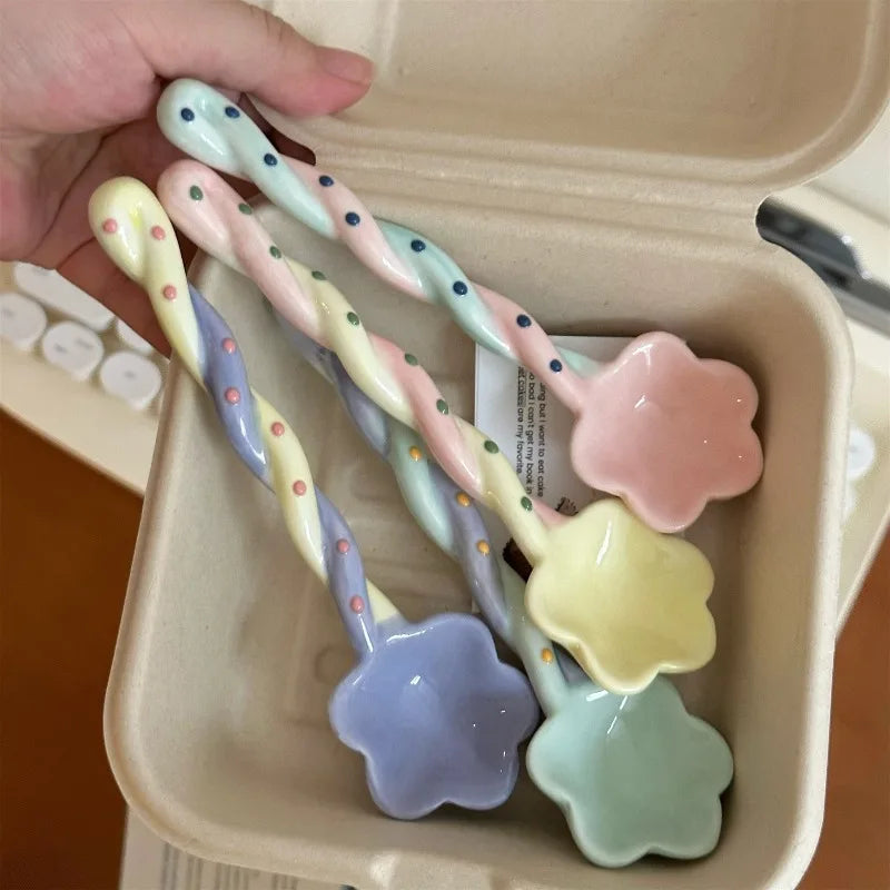 Four rainbow colored kawaii spoons inside a tray
