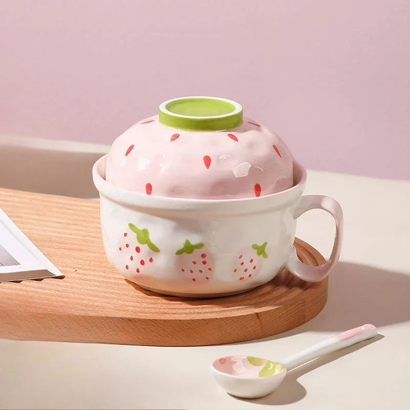 A strawberry designed kawaii bowl next to a spoon
