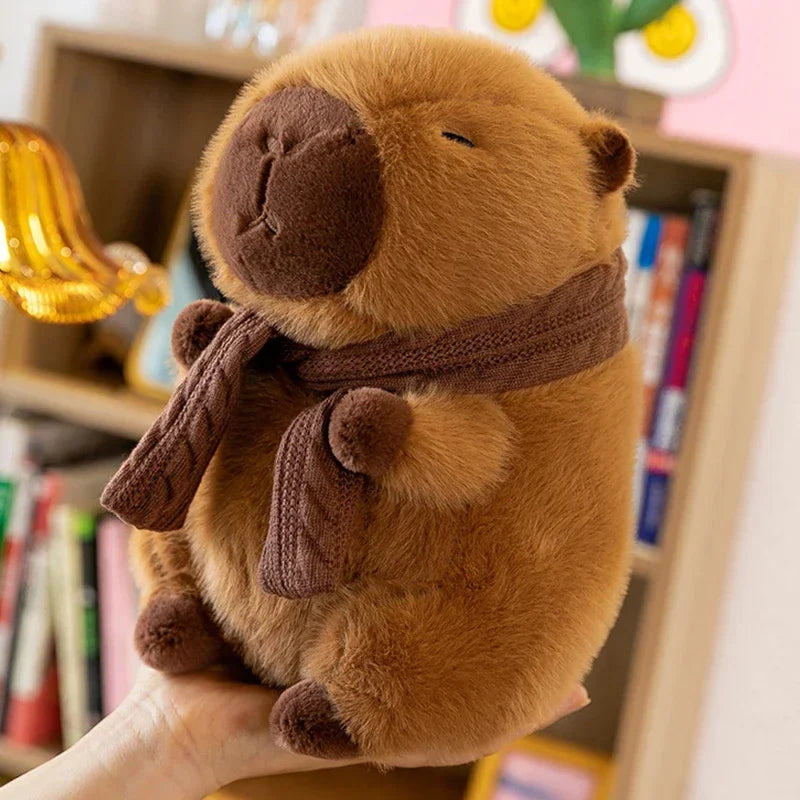 Kawaii plush toy beaver with a scarf held in front of a bookshelf.