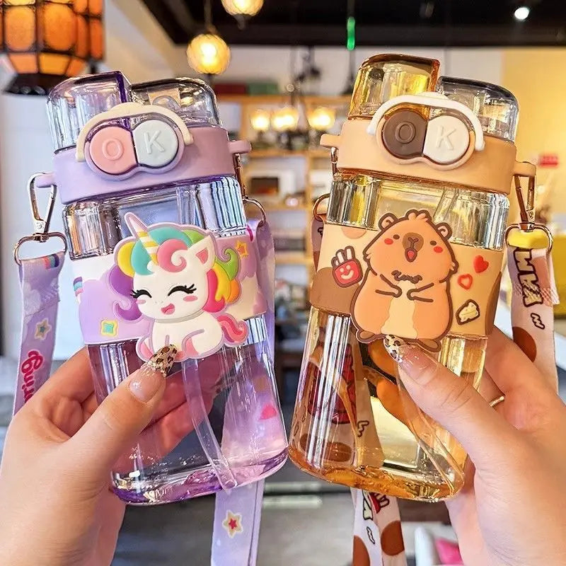 Two cute kawaii water bottles with cartoon designs held by hands in a casual setting.