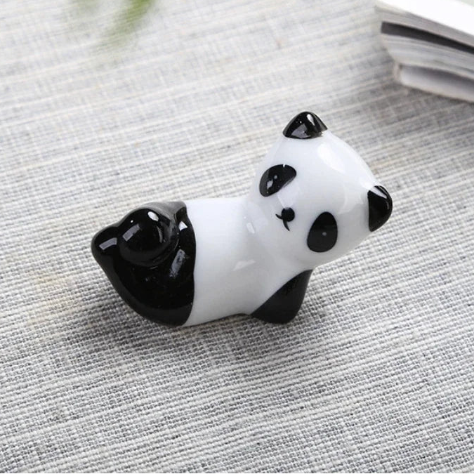Panda-shaped kawaii chopstick holders on a textured surface with dimensions displayed