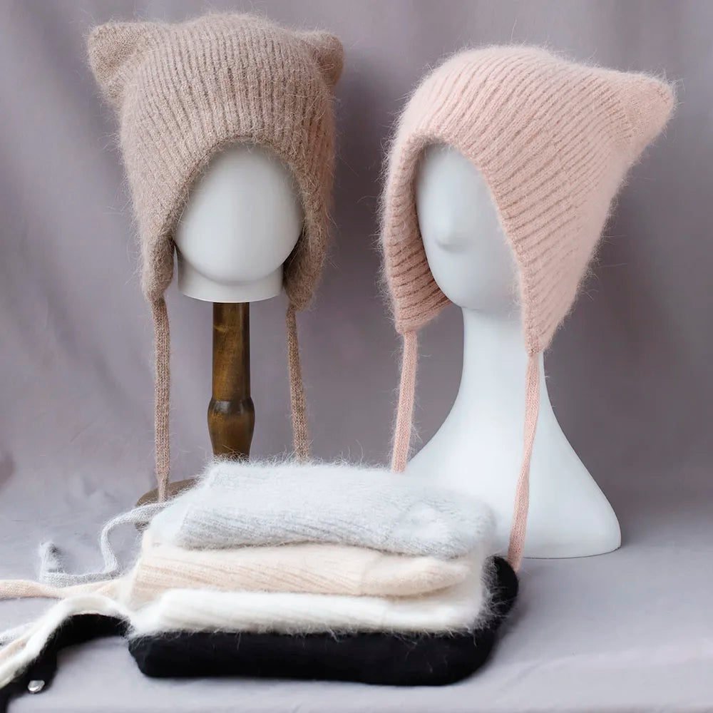 Two knitted Kawaii hats on mannequins with a gray background
