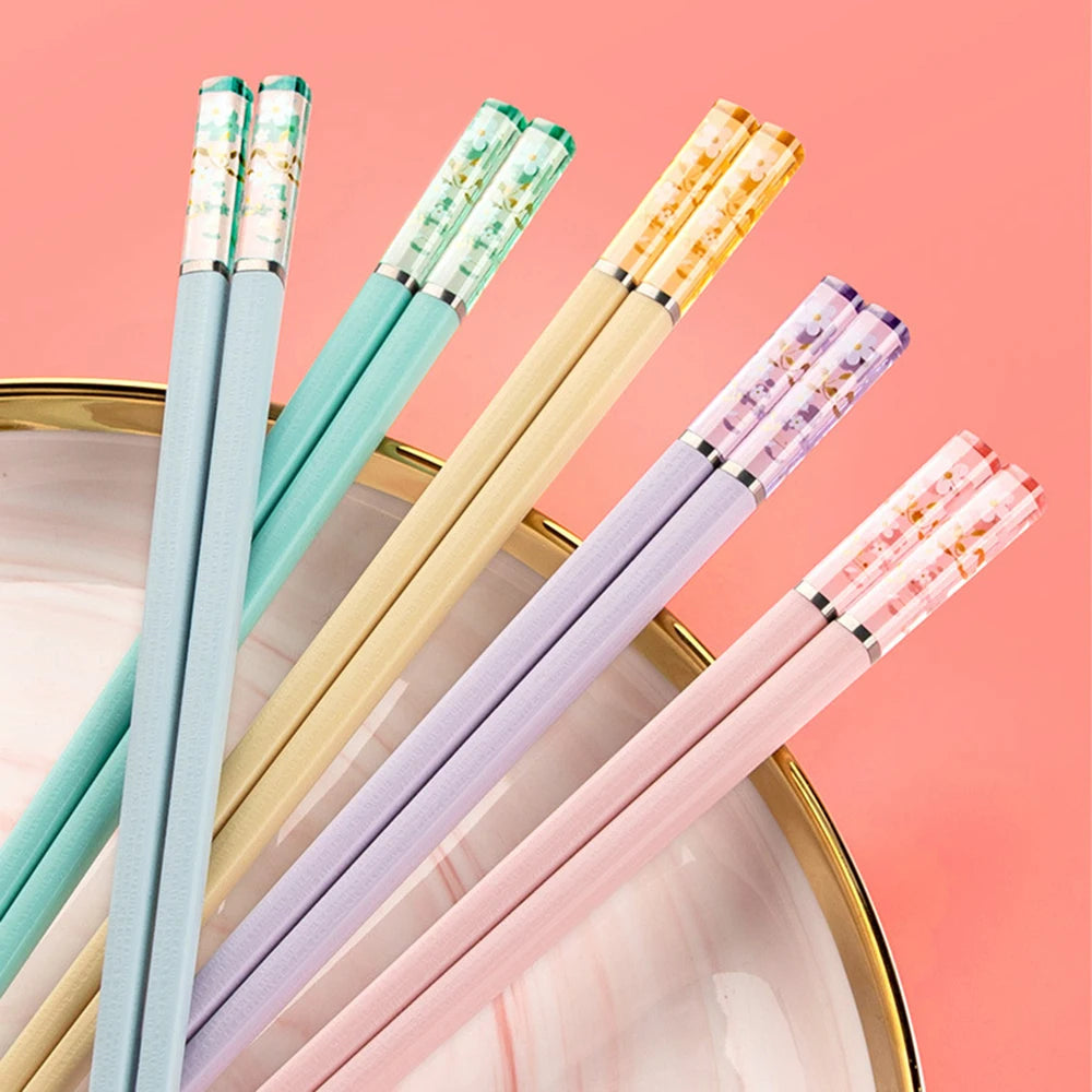 Set of colorful kawaii chopsticks on a pink background