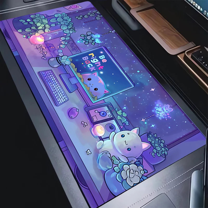 A large desk mat with a detailed anime-style illustration of a white cat in a cozy room, shown laid out on a dark desk next to a keyboard and mouse.