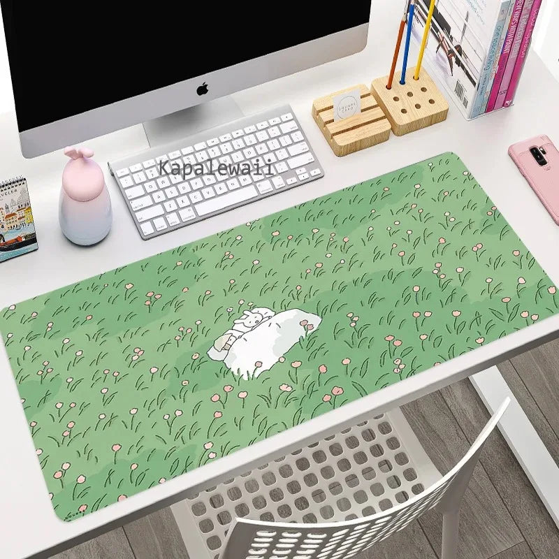 Desk setup with a green mouse pad featuring a Kawaii cartoon design, keyboard, and office items.