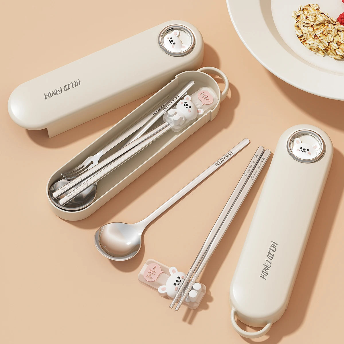 Set of stainless steel kawaii utensils with cute animal-shaped handles in a beige carrying case on a beige background.