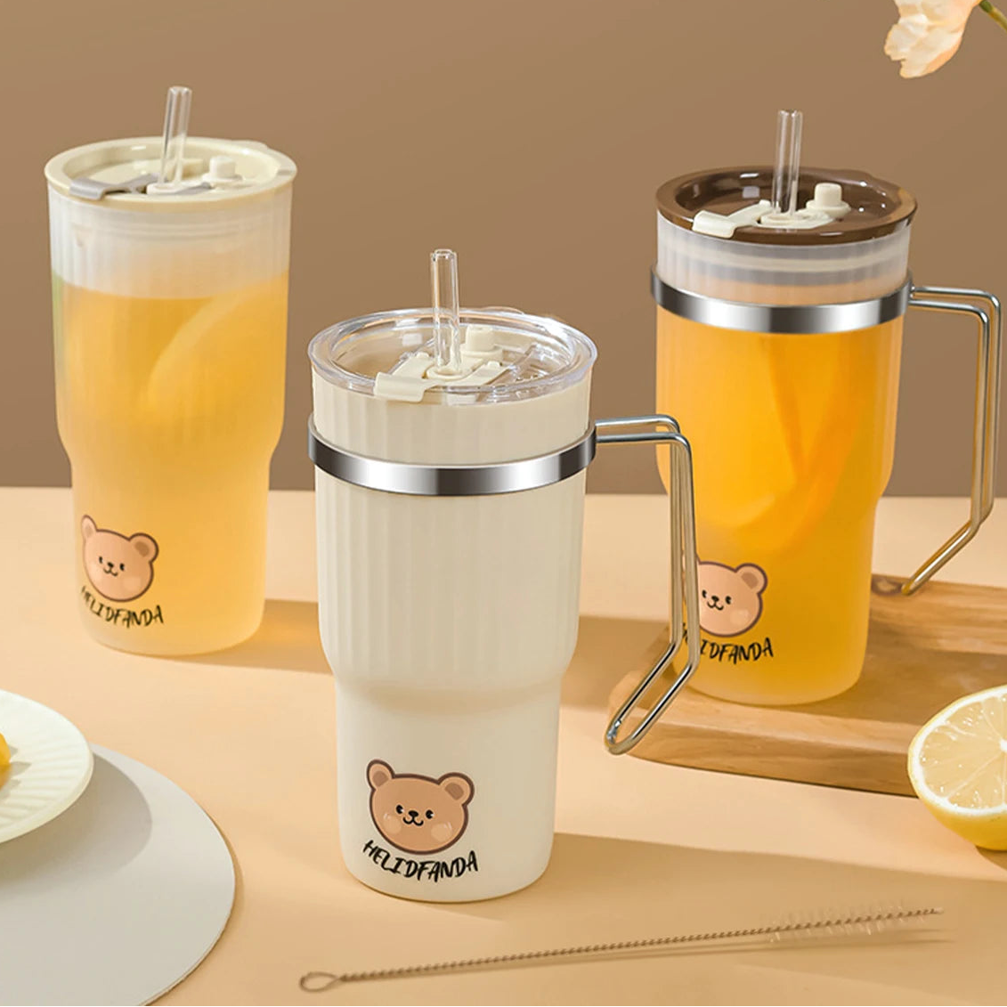 Three portable kawaii cups with bear designs on a wooden surface, containing drinks.