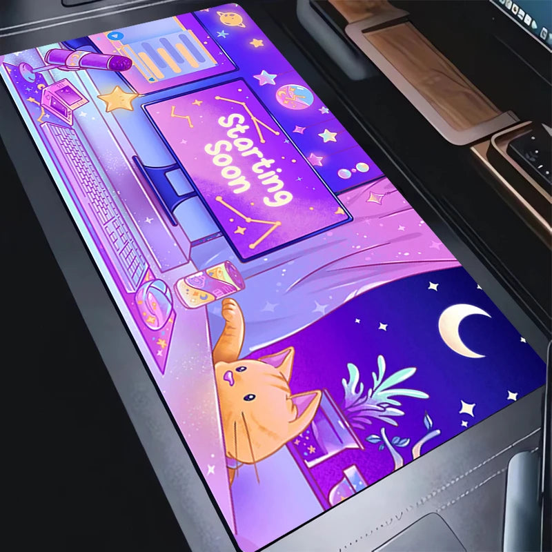 A close-up of a laptop trackpad or desk mat featuring a colorful cartoon illustration with a sleeping orange cat under a crescent moon, stars, and a purple 'Starting Soon' screen.