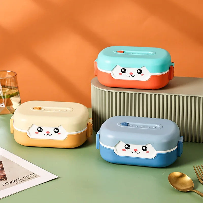 Three cartoon-style kawaii lunch boxes on a green surface with an orange wall background.