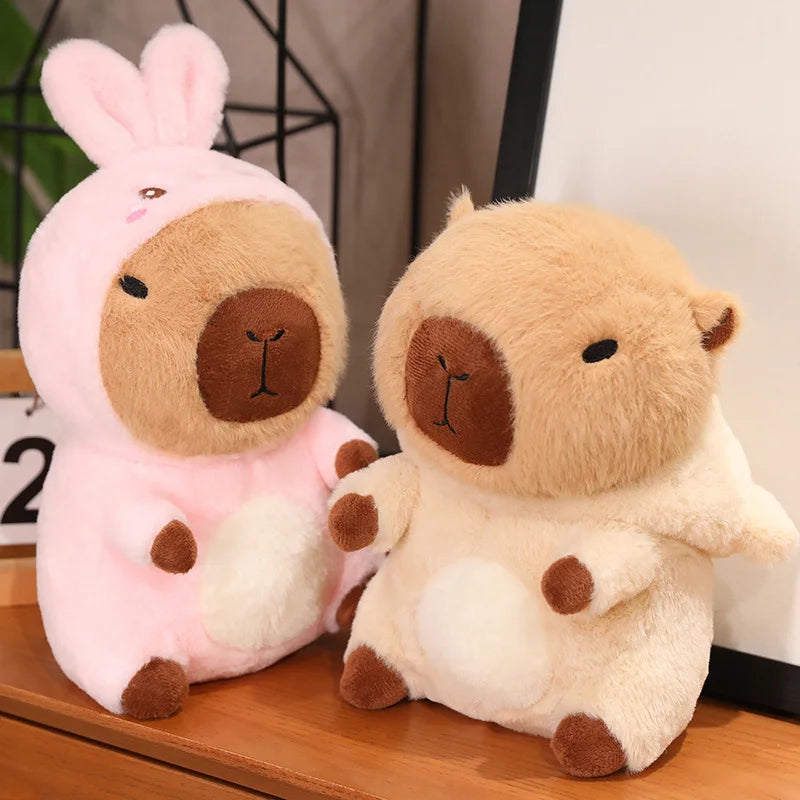 Two kawaii plush toys, one pink and one beige, sitting on a wooden surface.