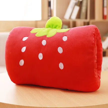 Strawberry-shaped kawaii cushion on a wooden surface with a blurred background