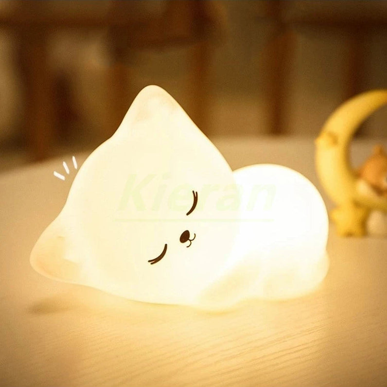 Cute kawaii ghost-shaped night light on a wooden surface with a blurred background
