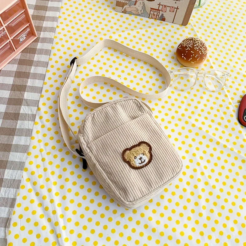 Beige corduroy bag with bear patch on a yellow polka dot tablecloth