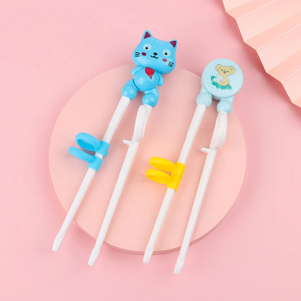 Two kawaii cartoon-themed children's chopsticks on a pink background